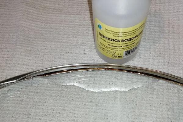 Ramollir la graisse sous le rebord du couvercle avec du peroxyde d'hydrogène