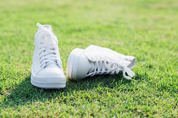 Baskets blanches sur la pelouse