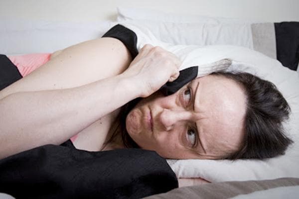 Le bruit des voisins à l'étage empêche une femme de s'endormir