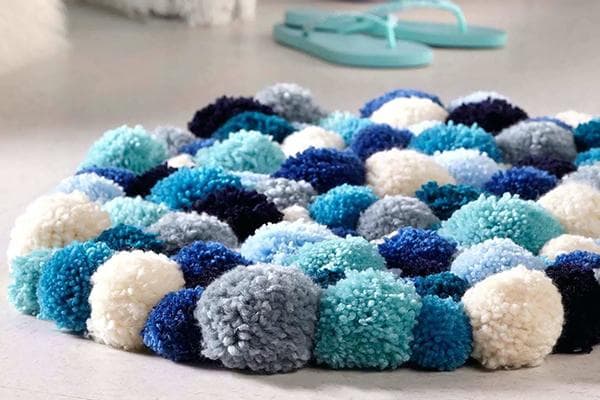Tapis composé de pompons dans les tons bleus