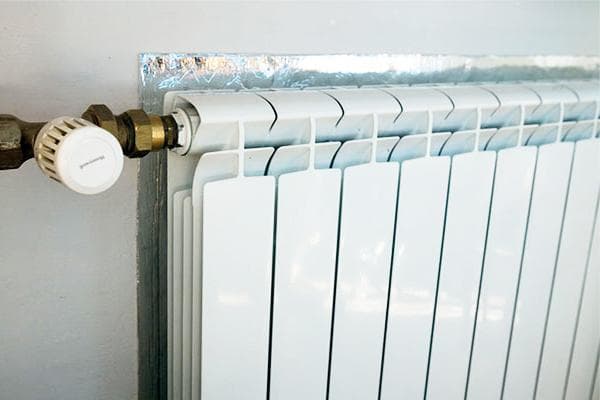 Écran en matériau calorifuge derrière le radiateur