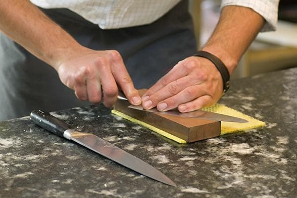 L'homme aiguise un couteau