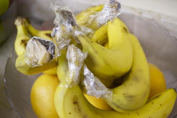 Bananes avec film alimentaire sur les pétioles