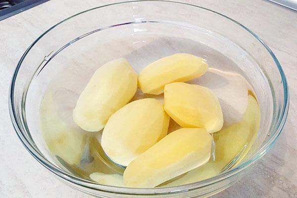 Pommes de terre pelées dans un bol d'eau