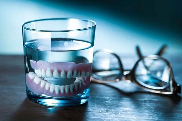 Dentier dans un verre d'eau