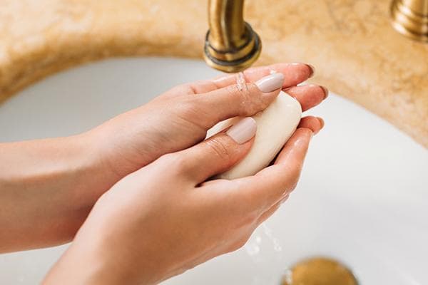 Femme se lavant les mains avec du savon de toilette