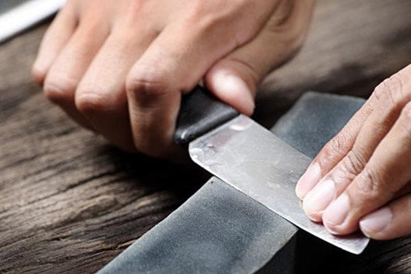 Aiguiser un couteau sur une pierre à aiguiser