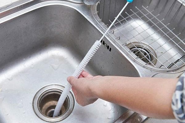 Utiliser une corde de plombier pour déboucher un évier