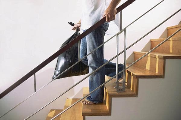 Un homme porte un sac poubelle