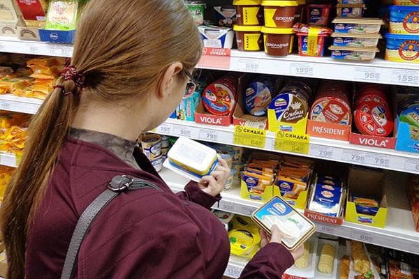 Femme choisissant du fromage fondu dans un supermarché