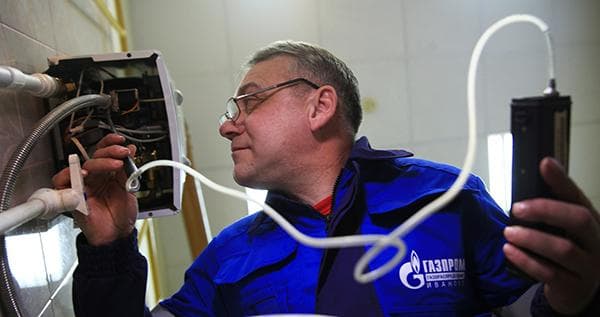 Un spécialiste du service de gaz vérifie un chauffe-eau à gaz