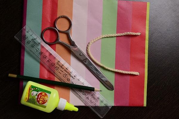 Sac cadeau, ciseaux, règle, crayon et colle