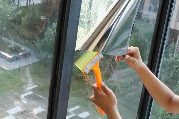 Coller un film réfléchissant sur une fenêtre