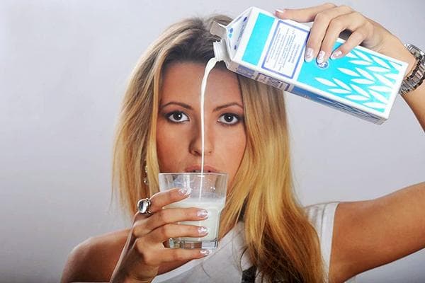 La fille verse du lait dans un verre