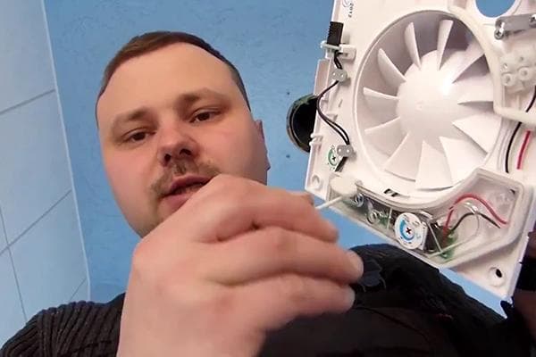 Homme réparant un ventilateur d'extraction