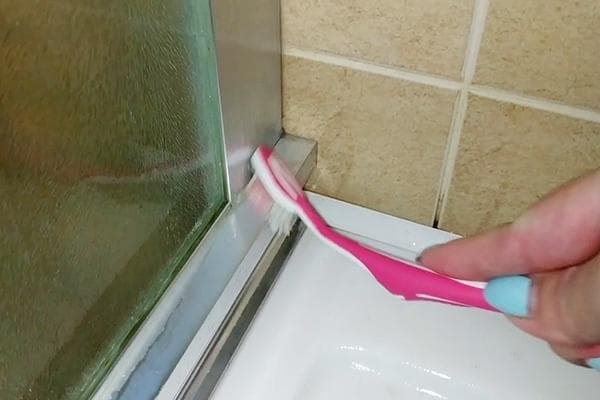 Nettoyer la cabine de douche de la moisissure avec une brosse à dents