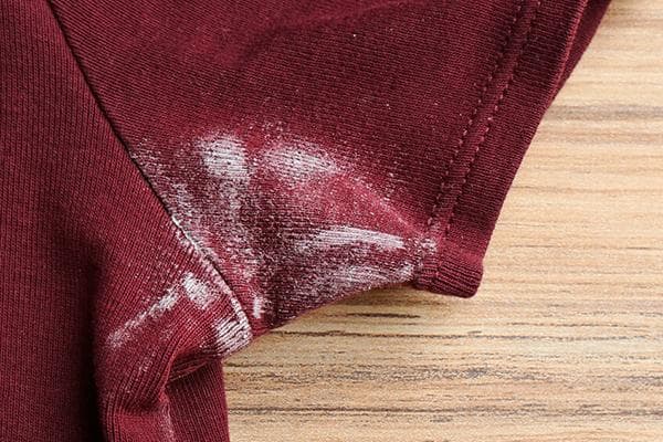 Marques blanches sous les bras sur un T-shirt