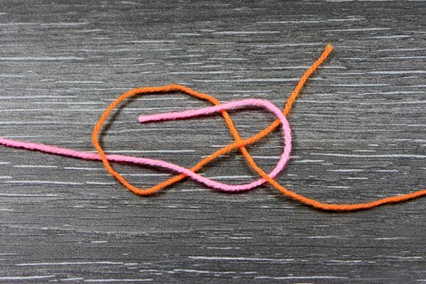 Tisser un noeud sur des fils de laine
