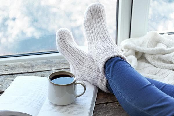 Des chaussettes en laine et une tasse de thé