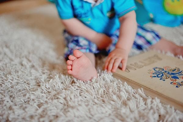 Un enfant est assis sur un tapis à poils longs