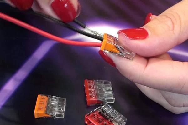 Femme reliant les fils avec le bornier