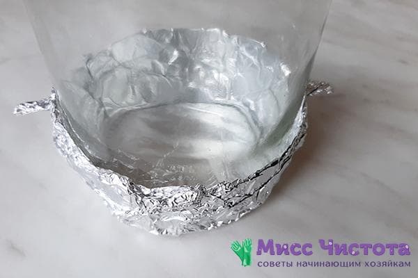 Pot en verre enveloppé de papier d'aluminium sur le fond