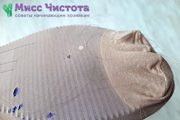 Cheveux sur une chaussette en nylon portée sur une pantoufle