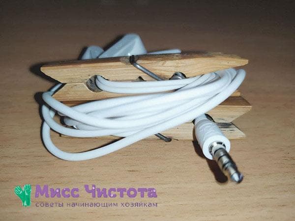 écouteurs enroulés sur deux pinces à linge collées