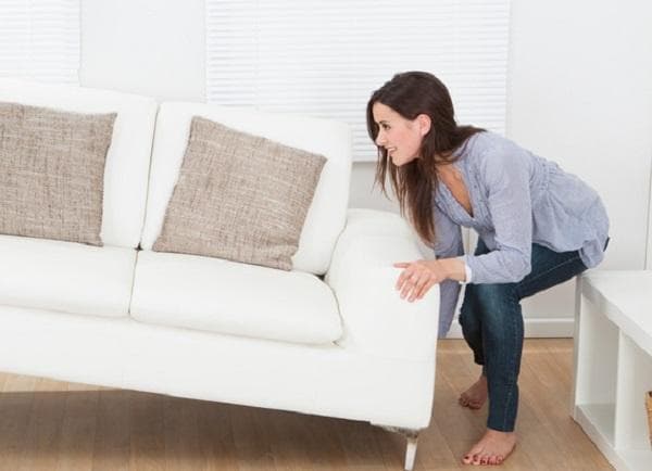Fille déplaçant le canapé