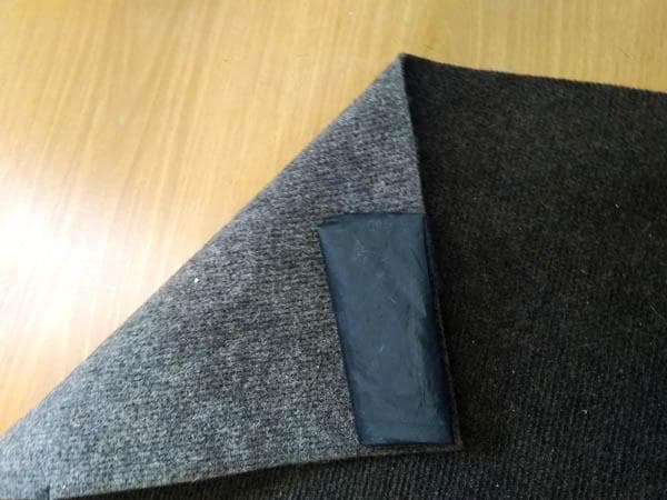 un morceau de caoutchouc collé au dos du tapis