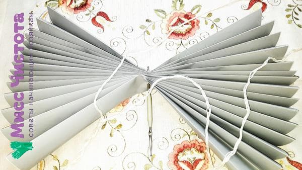 enfiler une ficelle dans des stores en papier