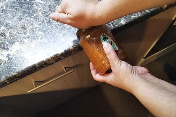 en retirant le couvercle du pot