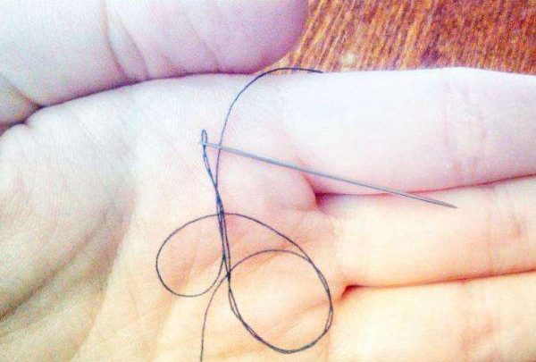 Paume avec fil et aiguille