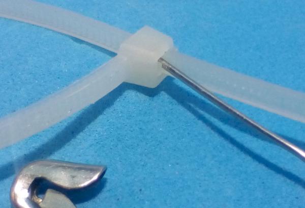 Détachez la pince en nylon avec une épingle